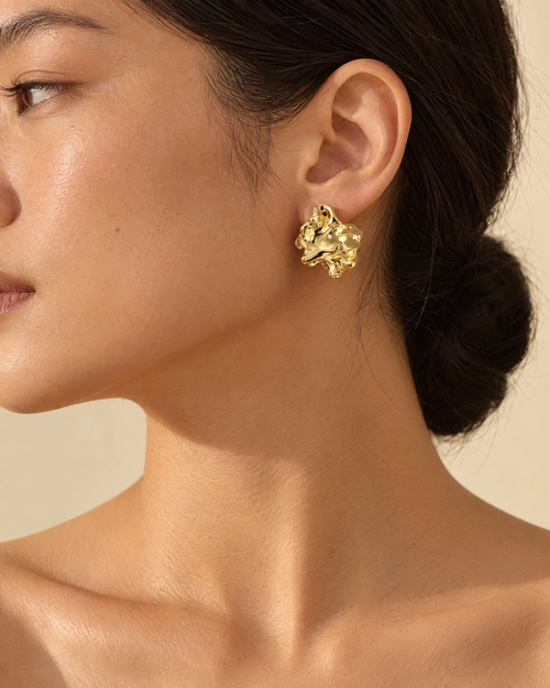 Molten gold stud worn on ear