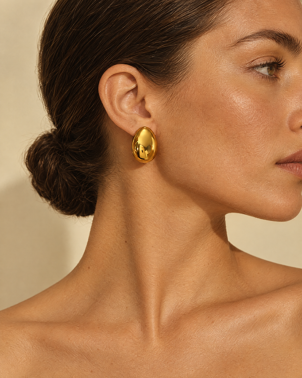 Gold dome earring worn on ear