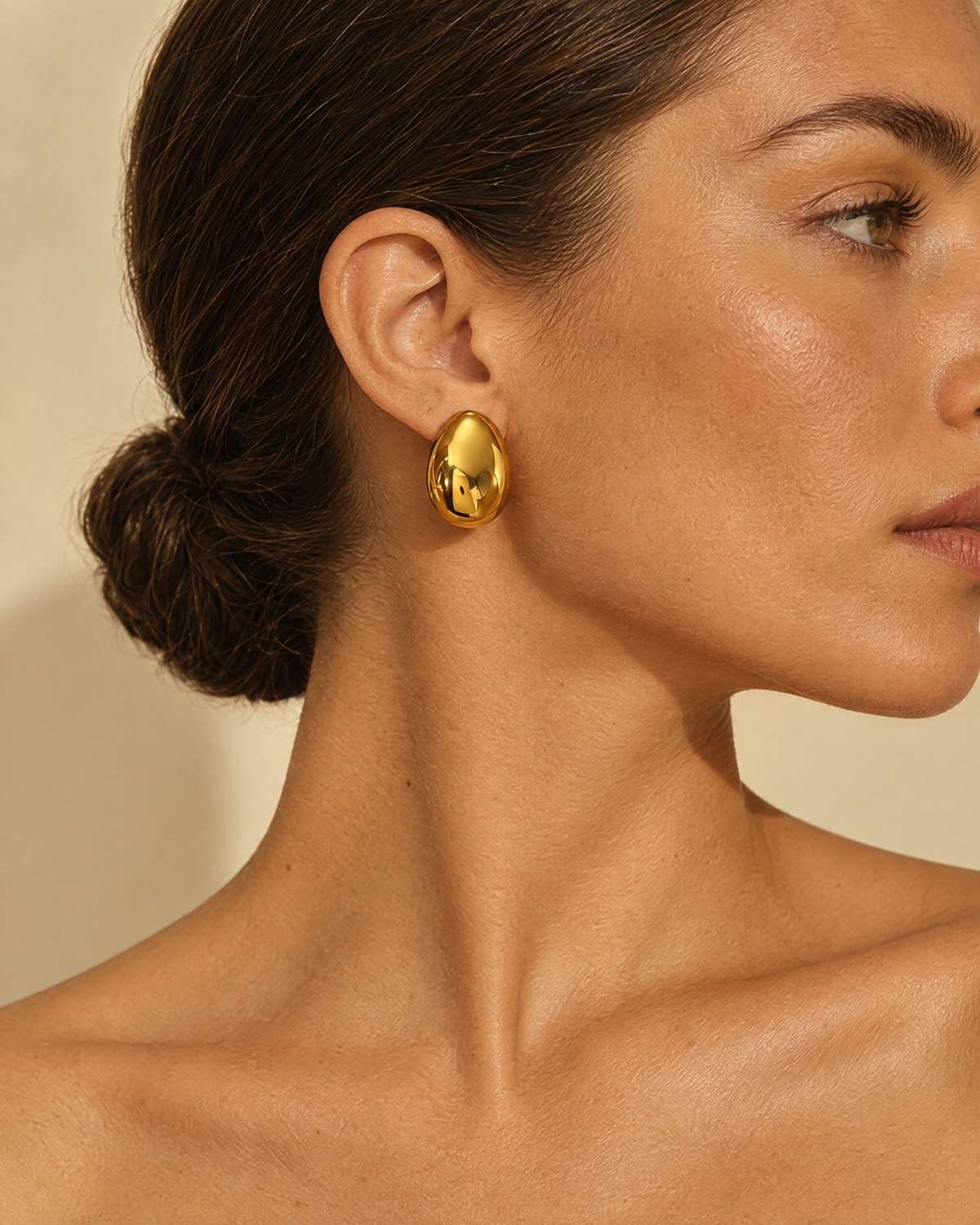 Gold dome earring worn on ear
